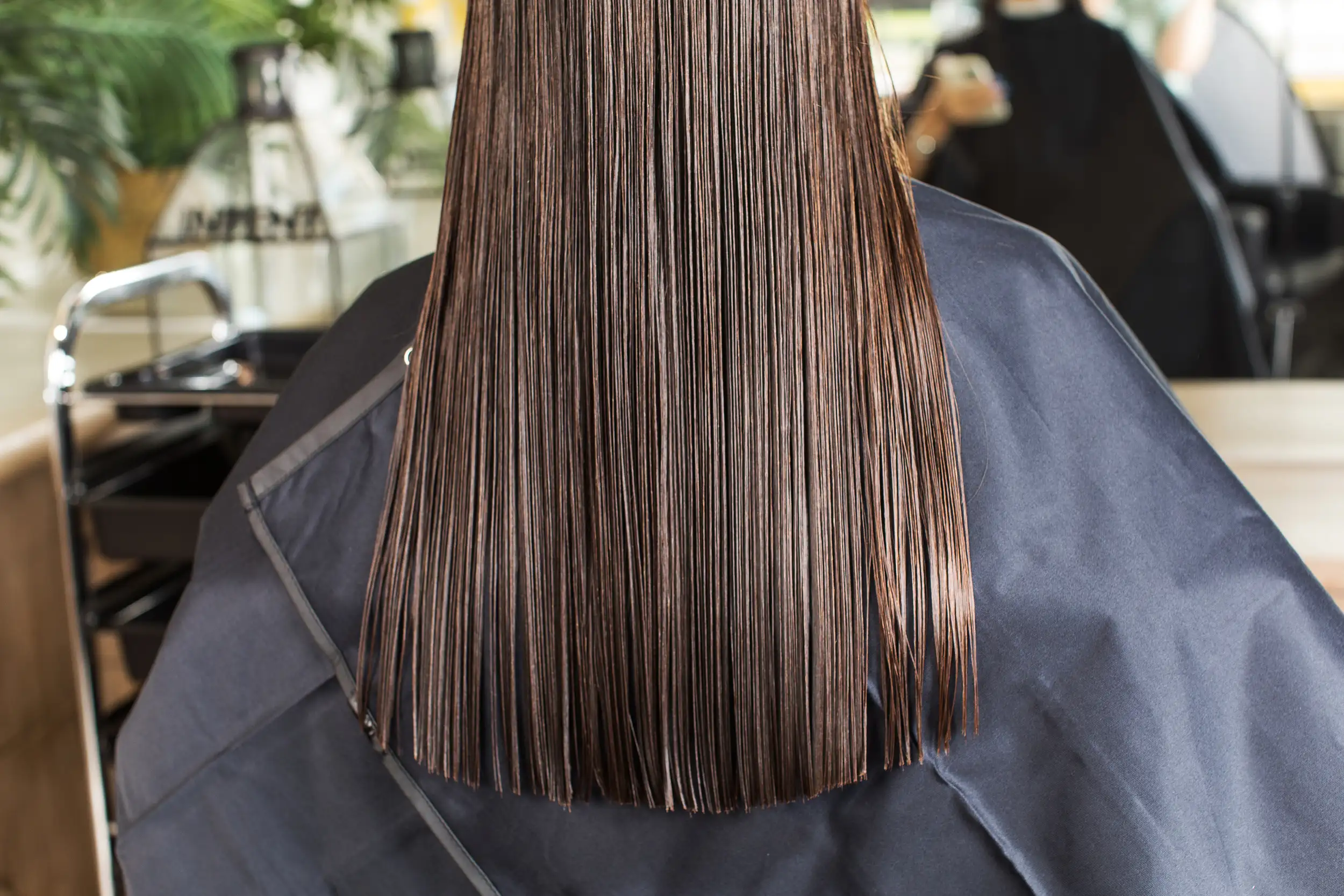 A client getting her hair treated with keratin chemicals